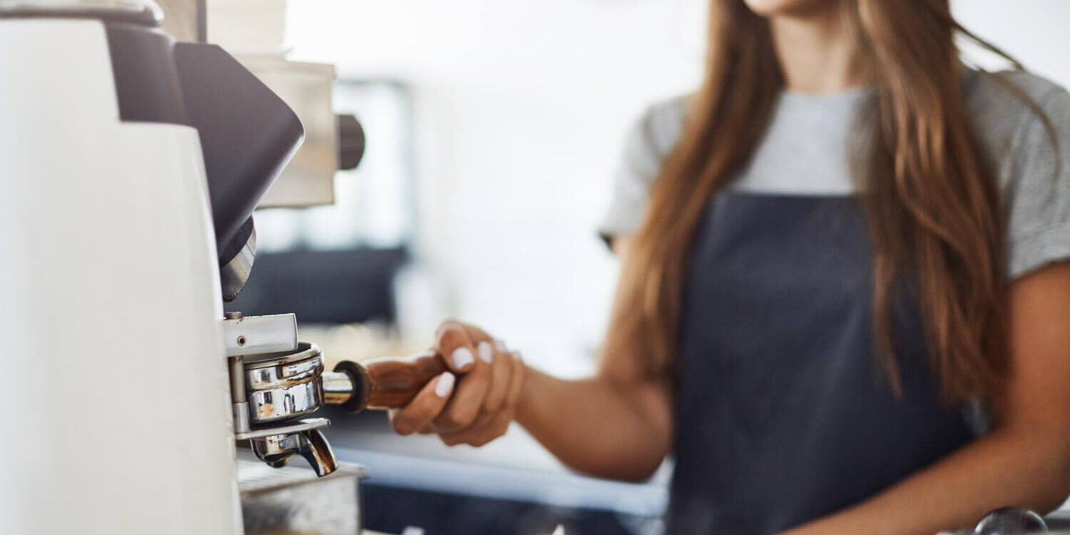 close-up-of-female-barista-grinding-coffee-to-make-a-perfect-espresso-cup-in-a-bright-cafe-on-a-sunny-winter-day