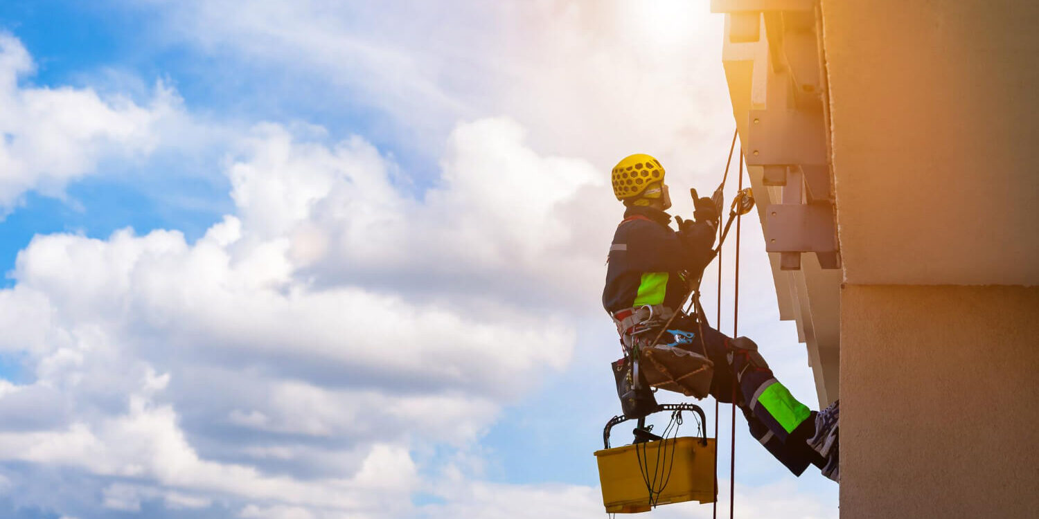 industrial-mountaineering-worker-in-uniform-washing-exterior-glazing