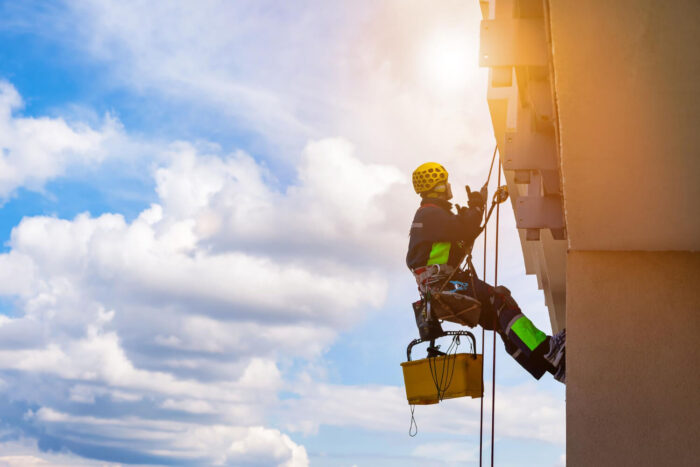 industrial-mountaineering-worker-in-uniform-washing-exterior-glazing