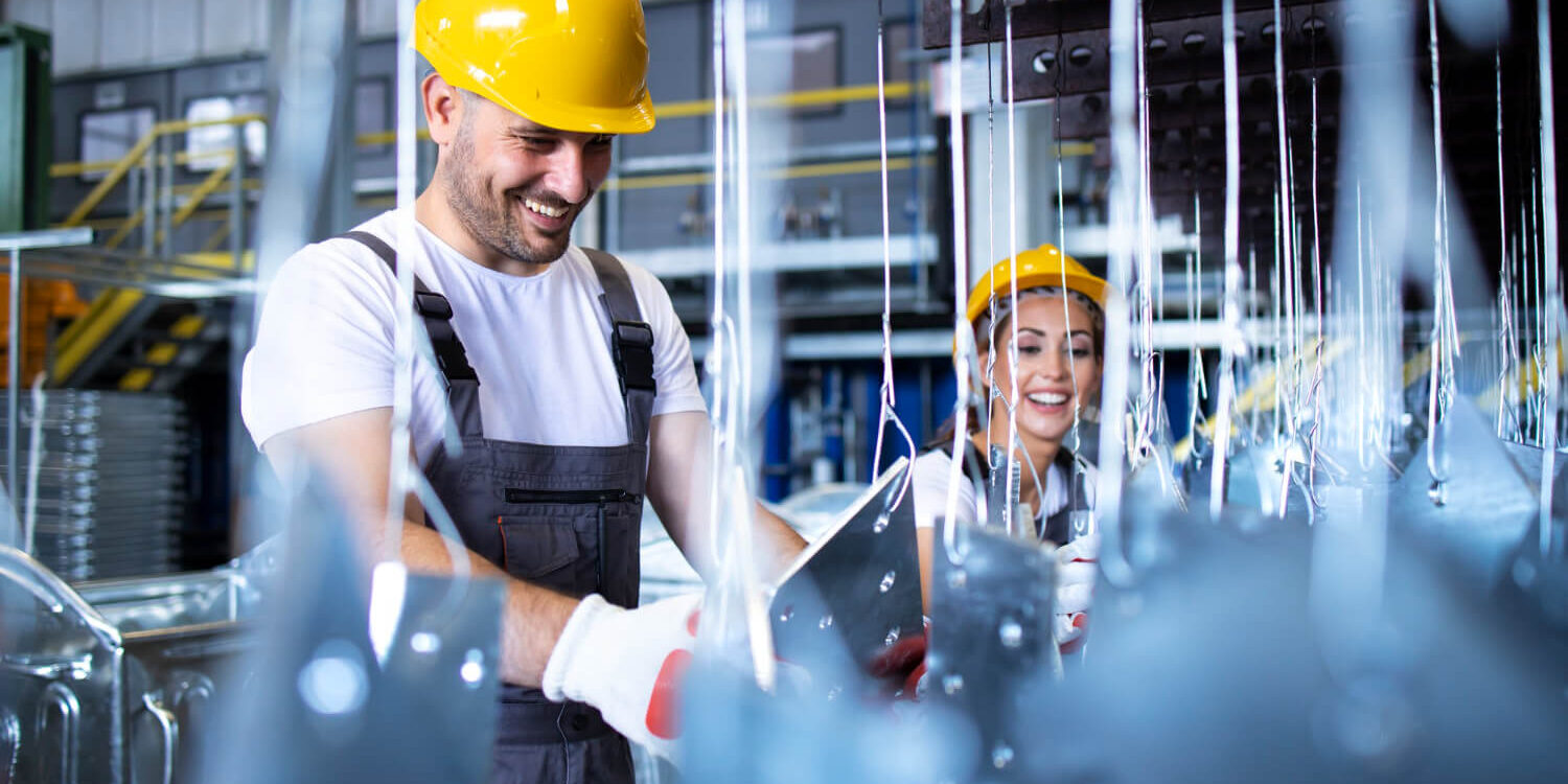 workers-in-uniforms-and-yellow-protective-hardhats-working-in-factory